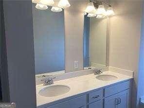 bathroom featuring double vanity, a sink, and a chandelier