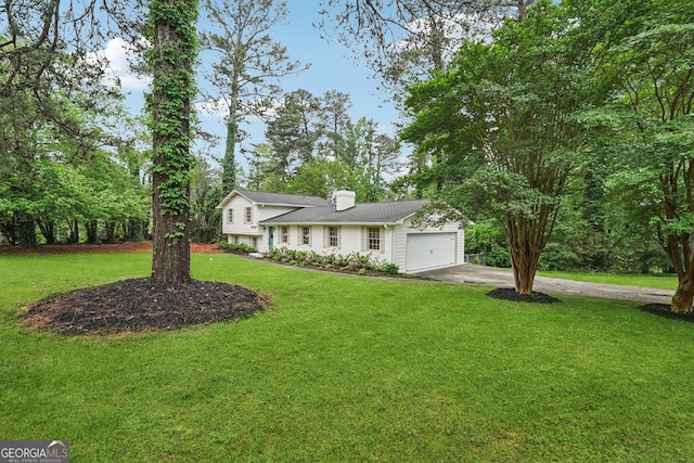 tri-level home featuring a chimney, concrete driveway, a front lawn, and a garage
