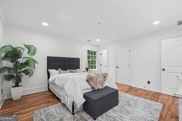 bedroom featuring ornamental molding, recessed lighting, and wood finished floors