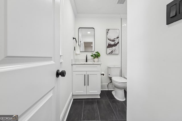 bathroom with ornamental molding, toilet, vanity, and baseboards