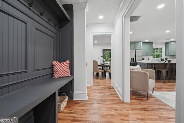 mudroom with recessed lighting, light wood-style floors, ornamental molding, baseboards, and visible vents