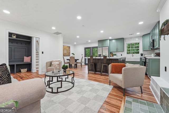 living room with recessed lighting, a wealth of natural light, and light wood-style flooring