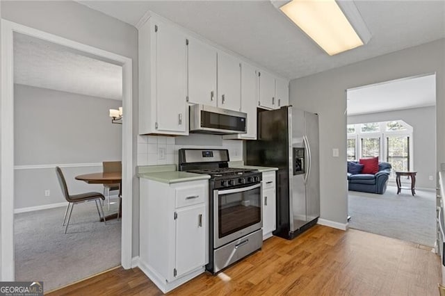 4811 Nevilly Way, Marietta, GA 30066 - kitchen with baseboards, light wood-style flooring, stainless steel appliances, light countertops, and white cabinetry