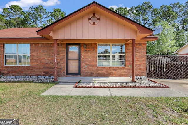 1467 Enterprise Dr, Hinesville, GA 31313 - view of front of house with fence, a front lawn, and brick siding