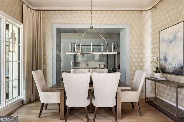dining room with wallpapered walls and light wood finished floors
