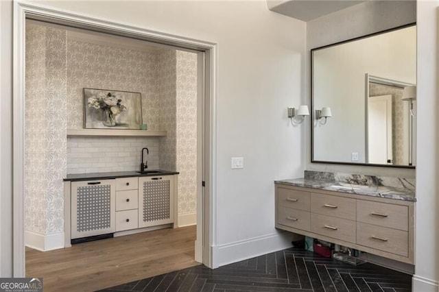bathroom featuring baseboards, wood finished floors, and vanity