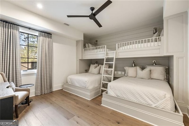 bedroom with baseboards, ceiling fan, light wood-type flooring, and visible vents