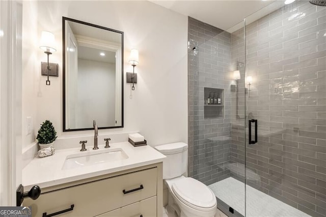 bathroom with vanity, toilet, and a stall shower