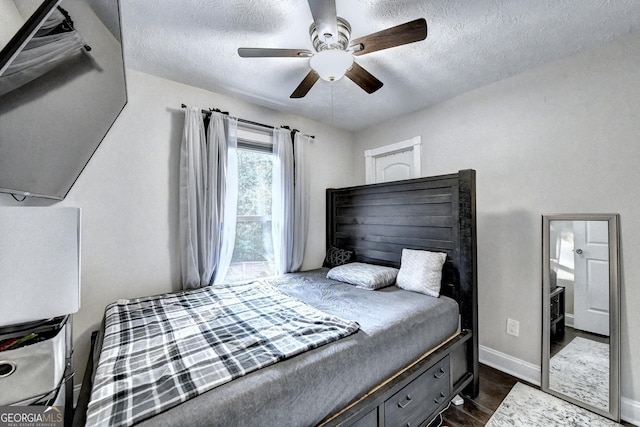 4364 Saddlecreek Ct, Auburn, GA 30011 - bedroom featuring a textured ceiling, a ceiling fan, dark wood-type flooring, and baseboards