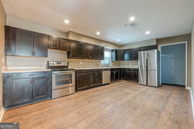 4806 Rockbridge Rd, Stone Mountain, GA 30083 - kitchen with stainless steel appliances, a sink, light wood finished floors, light countertops, and dark brown cabinetry