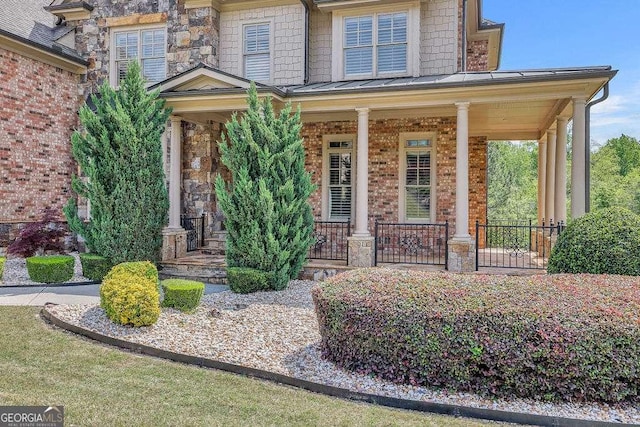 2932 Springbluff Ln, Buford, GA 30519 - craftsman-style home featuring brick siding, a standing seam roof, a porch, and a front lawn