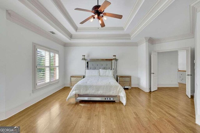 2932 Springbluff Ln, Buford, GA 30519 - bedroom featuring ornamental molding, baseboards, light wood-style flooring, and a tray ceiling