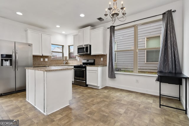 kitchen with stainless steel appliances, white cabinetry, backsplash, a chandelier, and recessed lighting