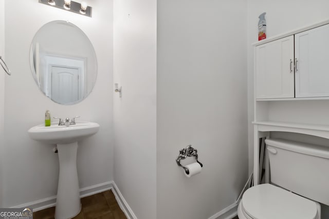 half bath with toilet and baseboards