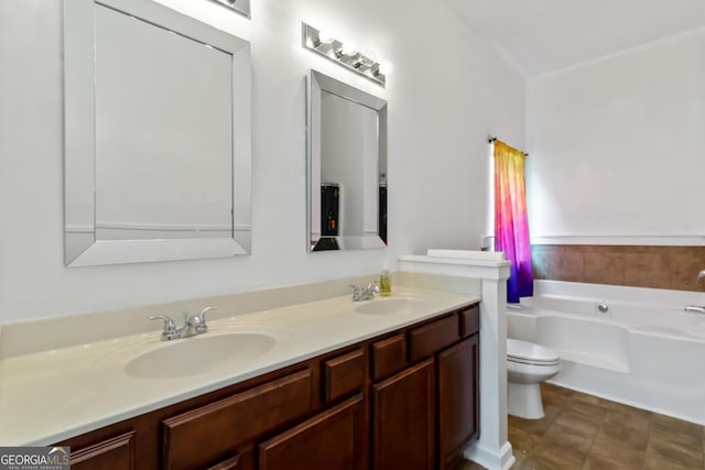 bathroom featuring a garden tub, double vanity, and toilet