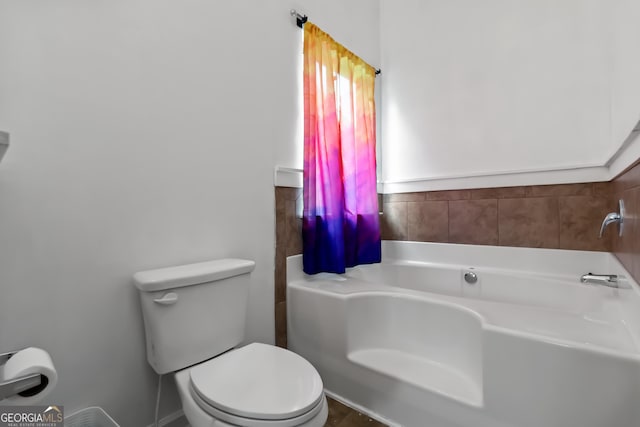 full bath featuring a garden tub and toilet