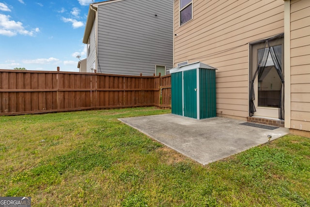 view of yard with a patio area, a storage unit, and an outbuilding