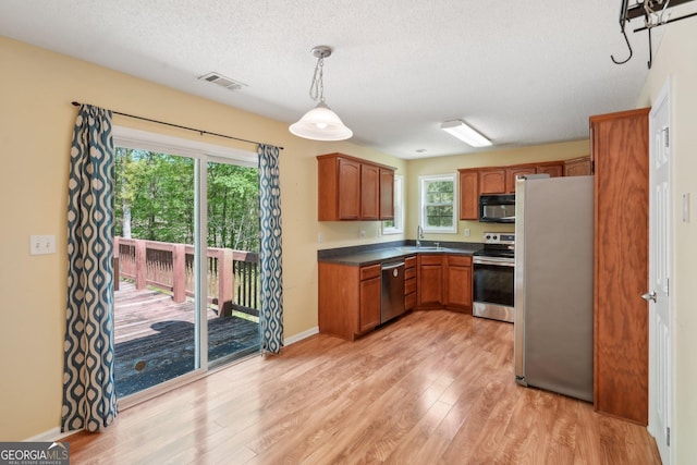 140 Spring Cir, Senoia, GA 30276 - kitchen featuring stainless steel appliances, light wood-type flooring, visible vents, dark countertops, and a textured ceiling