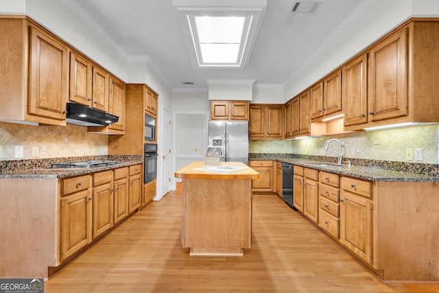 45 Herons Nest, Savannah, GA 31410 - kitchen featuring light wood-style floors, black appliances, a center island, a sink, and visible vents