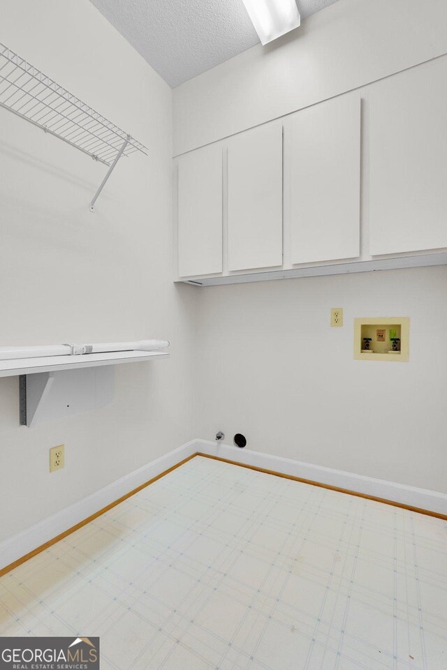 45 Herons Nest, Savannah, GA 31410 - washroom with washer hookup, a textured ceiling, hookup for a gas dryer, baseboards, and cabinet space