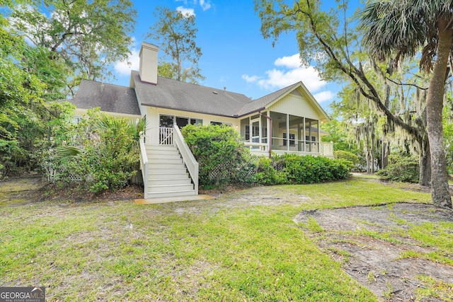 45 Herons Nest, Savannah, GA 31410 - rear view of house featuring a sunroom, stairway, a shingled roof, a lawn, and a chimney