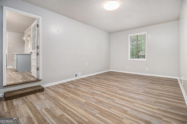 898 Doeskin Dr NW, Conyers, GA 30012 - empty room featuring light wood-style flooring, baseboards, and a textured ceiling
