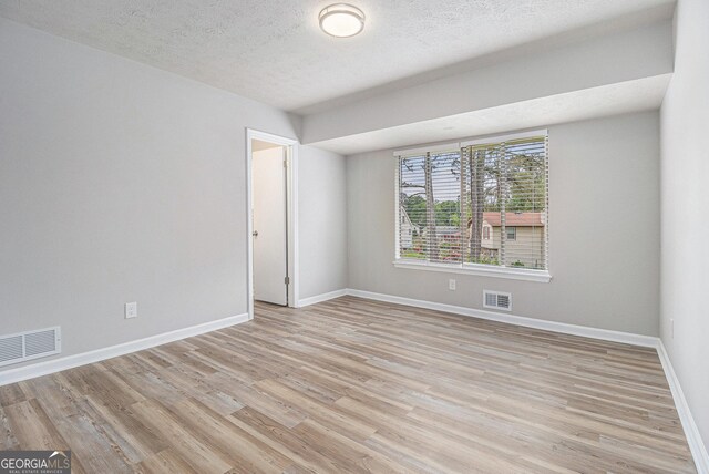 898 Doeskin Dr NW, Conyers, GA 30012 - empty room featuring light wood-type flooring, baseboards, and a textured ceiling