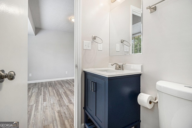 898 Doeskin Dr NW, Conyers, GA 30012 - bathroom featuring wood finished floors, toilet, vanity, and baseboards