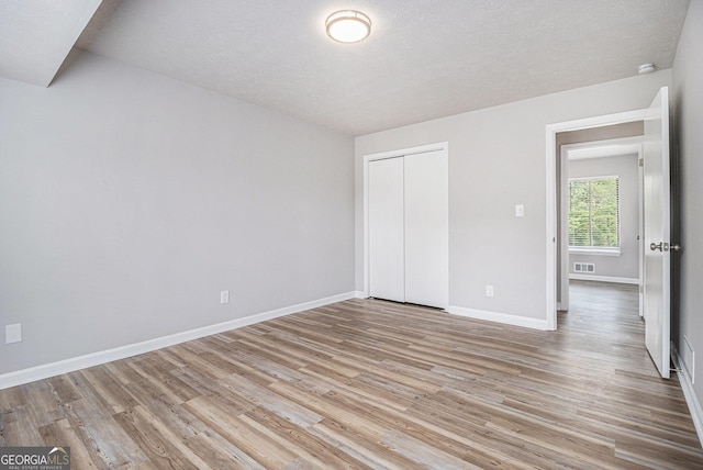 898 Doeskin Dr NW, Conyers, GA 30012 - unfurnished bedroom with light wood-type flooring, baseboards, and a closet