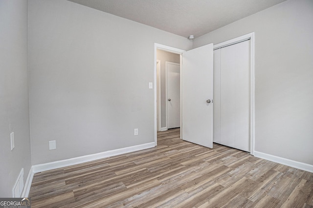 898 Doeskin Dr NW, Conyers, GA 30012 - unfurnished bedroom featuring light wood-type flooring, a closet, and baseboards