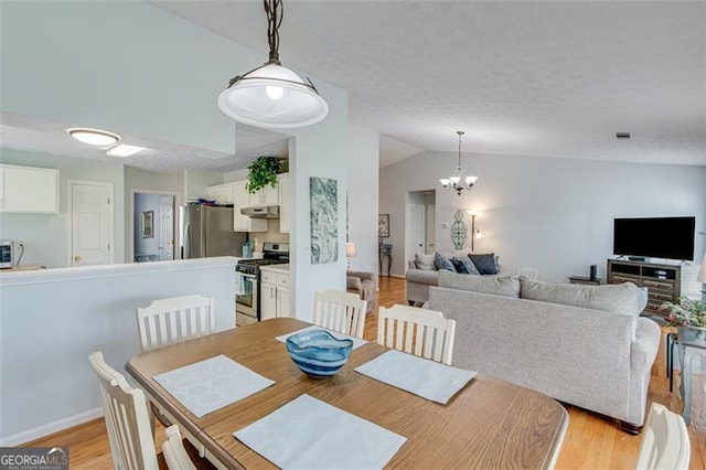 2602 Midler Ct, Buford, GA 30519 - dining room featuring a chandelier, light wood-type flooring, and lofted ceiling