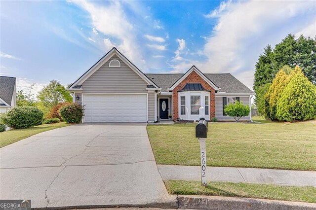 2602 Midler Ct, Buford, GA 30519 - view of front of home featuring an attached garage, driveway, a front lawn, and brick siding