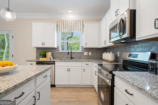 1027 Victoria Heights Dr, Dallas, GA 30132 - kitchen with appliances with stainless steel finishes, light wood-type flooring, plenty of natural light, white cabinets, and crown molding