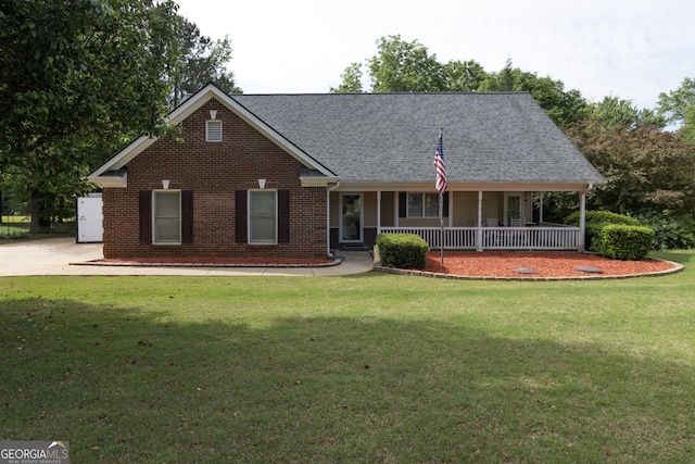 view of front of home with brick siding, a porch, a front lawn, and roof with shingles