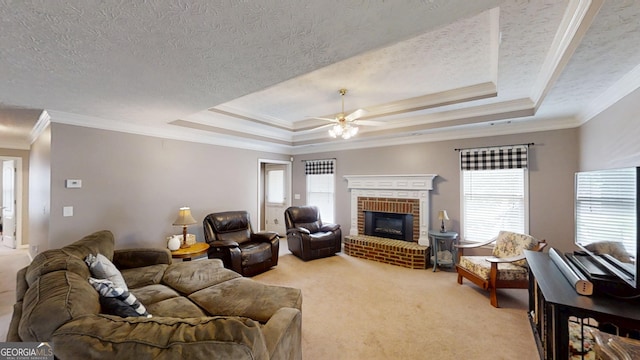 living area featuring ornamental molding, a ceiling fan, a tray ceiling, and carpet floors