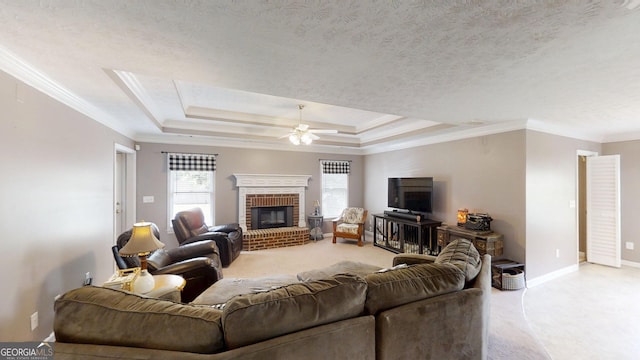 living area with ornamental molding, ceiling fan, light carpet, a brick fireplace, and baseboards