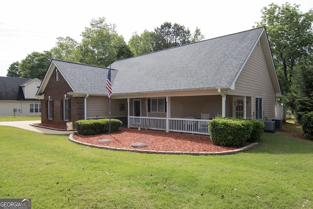 view of front of house featuring a porch, a front yard, roof with shingles, and brick siding