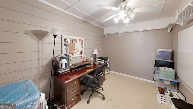 home office with wooden walls, ceiling fan, light colored carpet, and baseboards