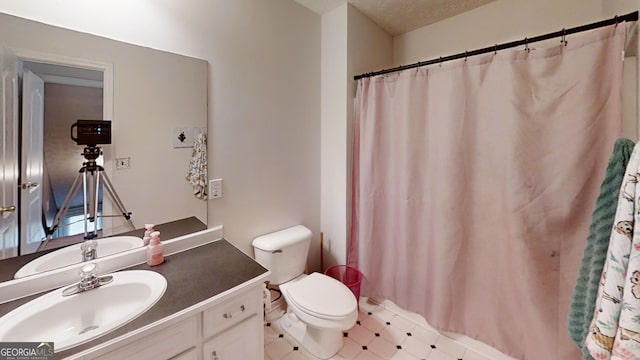 bathroom featuring toilet, curtained shower, and vanity