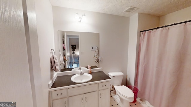 bathroom featuring a textured ceiling, a shower with curtain, visible vents, toilet, and vanity