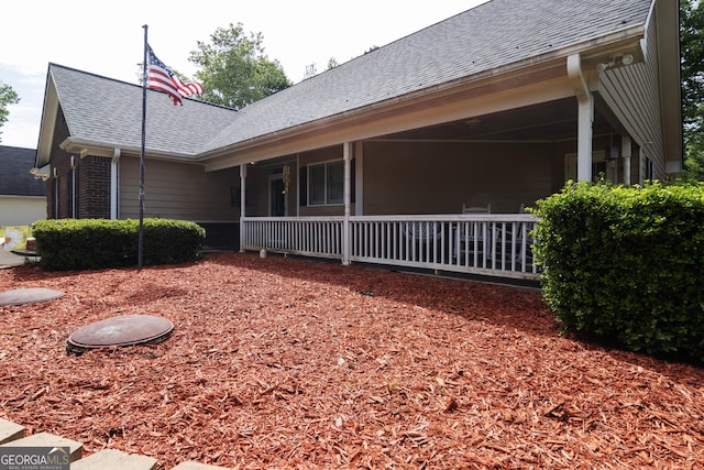view of property exterior with a porch and roof with shingles