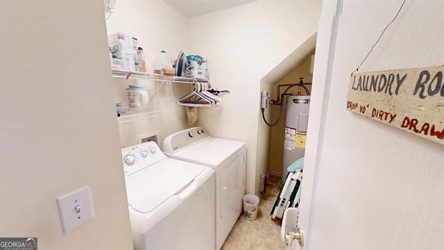 clothes washing area with water heater, separate washer and dryer, and laundry area