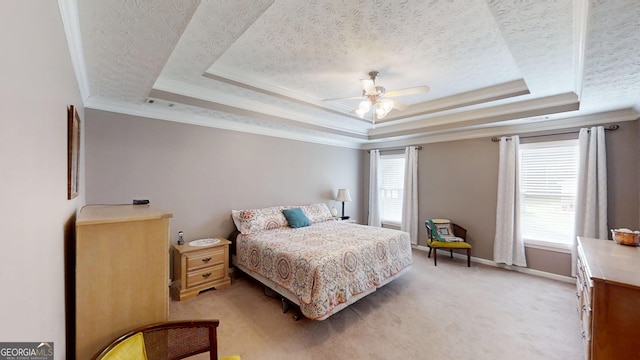 bedroom with baseboards, a raised ceiling, a textured ceiling, and light colored carpet