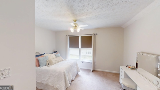 bedroom featuring a textured ceiling, ceiling fan, light colored carpet, and baseboards