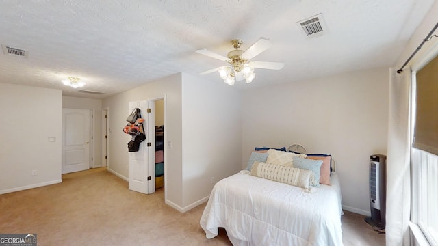 bedroom with visible vents, light carpet, a ceiling fan, and baseboards