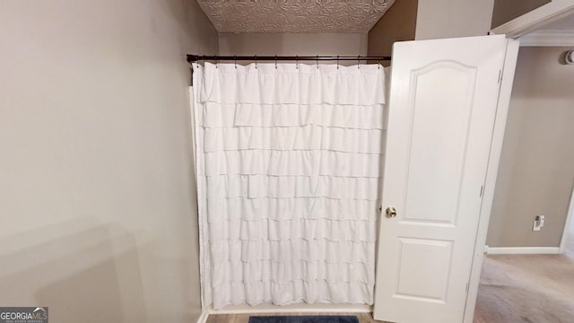 bathroom with baseboards and a shower with shower curtain