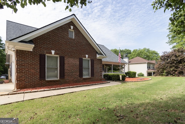 view of property exterior with a yard, a shingled roof, and brick siding