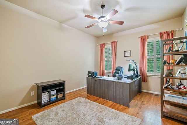 office space featuring baseboards, ceiling fan, and wood finished floors