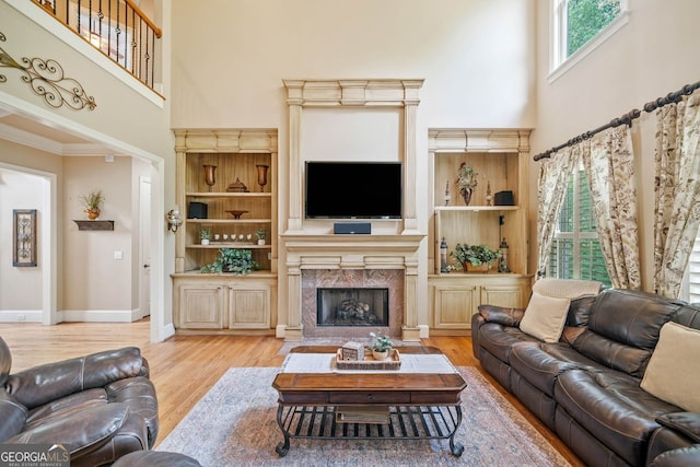 living area with wood finished floors, baseboards, and a high ceiling