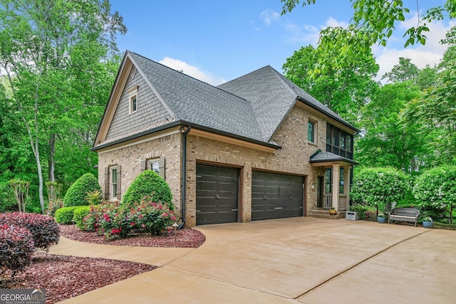 view of home's exterior featuring brick siding, driveway, roof with shingles, and a garage